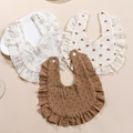 Close-up of three muslin cotton baby bibs with ruffle edges and soft floral patterns - Custom Color