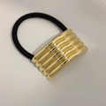 Elastic hair tie with five connected gold mirror metal rings in minimalist style - Curved Five Layer Gold