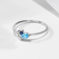 Macro view of sterling silver ring featuring oval sky blue and round deep blue gemstones - US 5 / Silver