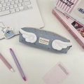 Gros plan d'une trousse bleue en toile avec des ailes en peluche et motifs d'étoiles - Bleu