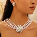 Détail du collier de perles à quatre rangs et boucles d'oreilles fleuries sur modèle - Parure de Bijoux en Perles Fleur à Quatre Couches (Argent Brillant 2827)