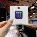 Dettaglio della spilla You Are The Solution con provette colorate su cartoncino - Provette (You Are The Solution)
