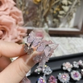 Macro detail of adjustable butterfly ring with pink rhinestones on a model's finger - Style 0600-Double Butterfly Design