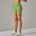 Macro view of high-waist avocado green yoga shorts showing smooth fabric texture and stitching - Medium Fruit Green