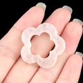 Pink quartz flower-shaped hollow pendant held by hand showing 30mm diameter size - White Crystal