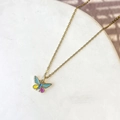 Detalle de un colgante de mariposa dorada con alas de esmalte de colores en cadena - Mariposa Azul Púrpura