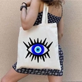 White canvas tote bag featuring a blue Greek Evil Eye print carried by a model - STD1804-N Minimalist Blue Pupil Eye