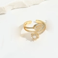 Détails d'une bague dorée ouverte avec zircon carré et motif de feuille étincelante - Zircone Blanc Carré
