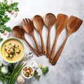 6-piece natural acacia wood kitchen utensil set with long handles on stone background - Soup Spoon/Slotted Spoon/Salad Fork/Flat Spatula/Angled Spatula/Rice Paddle