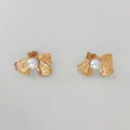Golden bow stud earrings with pearl center and textured metal finish on gray background - Gold Brushed Bow Earrings (D2875)