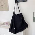 Detail of minimalist large capacity black canvas tote bag with front pocket and shoulder strap - Black
