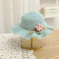 Detail view of light blue straw hat with 3D pink flowers and a wavy brim on a gold stand - Straw Hat Only / Lake Blue