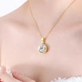 Elegante collana in titanio dorato con ciondolo rotondo in cristallo trasparente sfaccettato - Oro Bianco