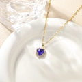 Detail of a gold heart necklace with a dark blue sapphire and micro-pave diamond halo - Royal Blue Pendant Necklace