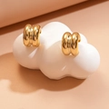 Macro shot of gold double-ribbed C-shape earrings on white cloud display stand - Steel Pin - Gold C-Shape