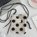 Detail of white plush crossbody bag with black polka dots and rope shoulder strap - White Background Polka Dots
