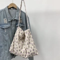 Detail view of corduroy tote bag with purple tulip floral print hanging on a hanger - Purple Tulip