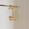 Detalle de un brazalete abierto multicapa dorado con acabados mate y pulido elegante - Dorado