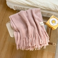 Pink chunky knit scarf with tassels and handmade label on a warm home background - Pink