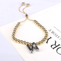 Close-up of golden beaded adjustable bracelet with silver W initial balloon charm - Letter N