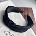 Detail of a black knotted fabric headband with matte texture on a rustic canvas bag - Black