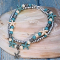 Double-layer turquoise bead anklet with silver starfish charm on a blue wooden board - Textured Starfish