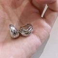 Vista macro de pendientes de aro minimalistas en U plateados con textura de diamante - Plateado
