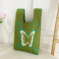 Macro detail of grass green knitted handbag featuring butterfly and star patterns - Green Butterfly Bag