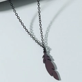 Detail view of the feather-shaped titanium steel pendant with a dark metallic finish - Feather / Black