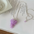 Detailed close-up of purple glass beaded grape cluster pendant on silver snake chain - Purple