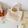 Close-up of the delicate hollow flower lace texture and logo on the crochet tote bag - Knitted Hollow Handbag