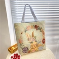 Floral rabbit pattern canvas tote bag with blue striped handles in lifestyle setting - Honey Rabbit