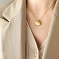 Franse schelpvormige hanger ketting en oorbellen set in goud gedragen door model - Ketting / 40+5cm / Goud