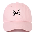 Close-up of pink cotton baseball cap featuring embroidered black bow ribbon detail - Pink