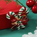 Detail of candy cane Christmas brooch with red bow and green holly leaves on red gift box - Red Green KC Gold (Candy Cane)