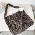 Macro shot of the leopard print canvas tote bag side label and woven strap detail - 4 Coffee Leopard Print