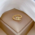 Detail eines goldenen Schlangenrings mit grünen Edelsteinaugen und Zirkonsteinen - Einstellbar Offen / Gold (Echtgold Vergoldet)