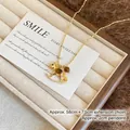 Vergoldete Schaukelpferd-Halskette mit Tigerauge und Kristallen auf beige Tablett - Halskette - Gold