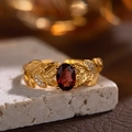 Macro shot of gold leaf-shaped ring with red garnet gemstone and small diamonds on stone - Natural Garnet Leafy Ring LR242