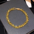 Pulsera dorada con hojas de circonita amarilla mostrada en un estuche de joyería - Pulsera de Empalme de Espiga de Trigo de Circonita