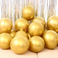 Close-up of golden metallic latex balloons with silver tinsel curtain backdrop decor - 12 Inch 2.8g Metallic Gold 50Pcs