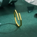 Anello geometrico dorato regolabile minimalista su uno sfondo di feltro verde scuro - Aperto Regolabile / Oro