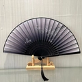 Traditional Chinese folding fan with plum blossom pattern and black tassel on a wooden stand - Arakawa Pine and Moon