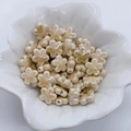 Dettaglio di perline in ceramica a forma di fiore color crema per gioielli fai-da-te - Caffè Chiaro