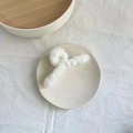 Elegant white plush hair claw clip for women made of soft faux fur on a ceramic plate - White Rabbit Fur