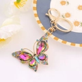 Detail of butterfly keychain with colorful crystals and iridescent gemstones on gold metal - Butterfly 18