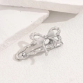 Macro detail of a silver bow hair clip featuring elegant pearls and rhinestones on stone - Silver Bowknot