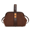 Close-up of retro dark brown shell bag featuring suede texture and gold metal clasp - Coffee