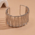 Detail view of woven hollow silver wide cuff bracelet on a minimalist display - Silver
