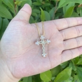 Detail of 18K gold plated cross pendant with cubic zirconia on palm background - Curved Intertwined Style (4#)